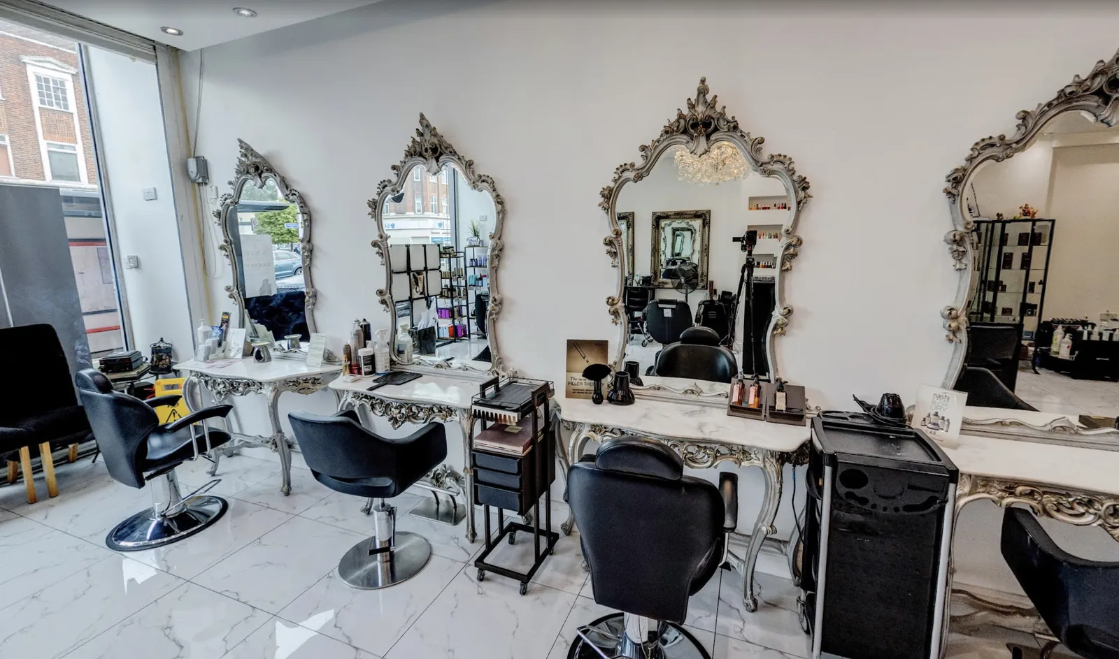 Styling stations at our Barkingside hair salon, with ornate silver mirrors and marble consoles