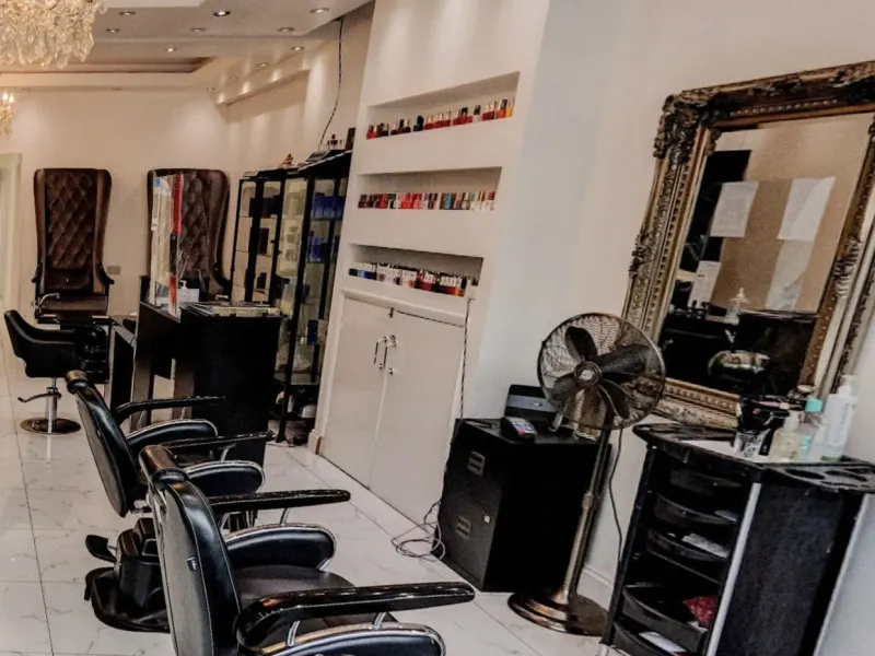 Nail polish shelves, a gilt mirror and styling chairs inside the salon