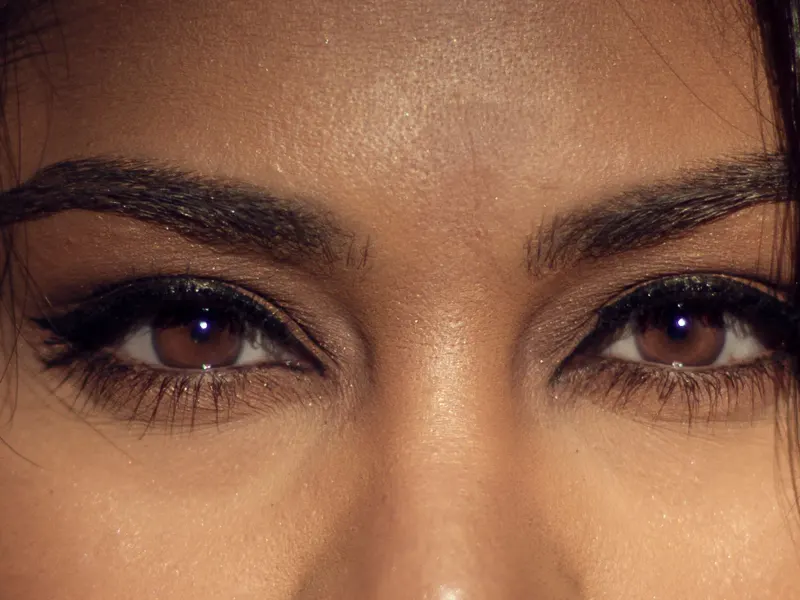 Close-up of a woman's brown eyes and full, shaped eyebrows