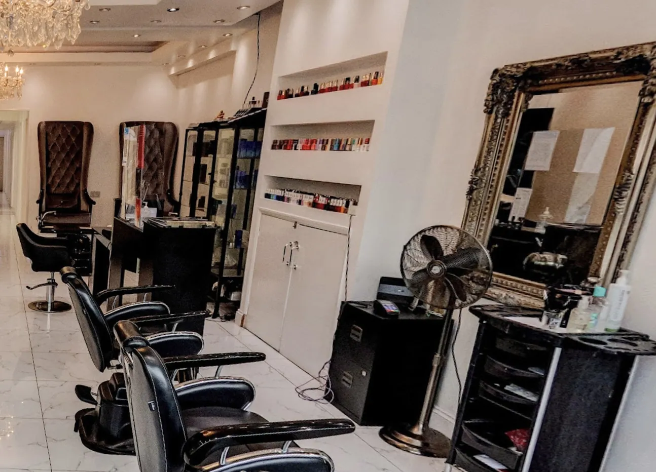 Nail polish shelves, a gilt mirror and styling chairs inside the salon